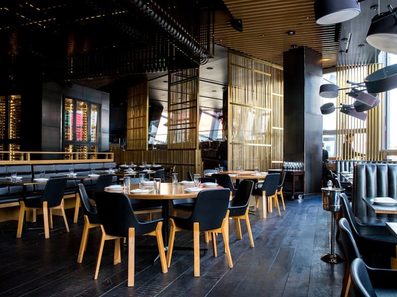 Warmly lit restaurant dining room with tables set for guests